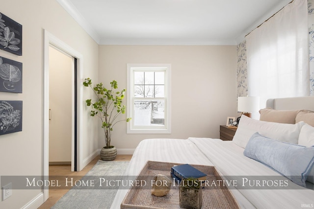 bedroom featuring baseboards, light wood-style floors, and crown molding