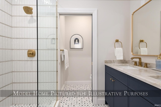 bathroom with double vanity, a stall shower, a sink, and toilet