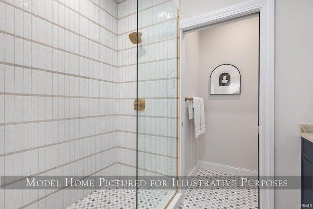 bathroom featuring a stall shower, vanity, baseboards, and tile patterned floors