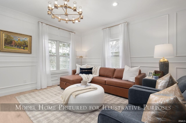 living room with crown molding, a healthy amount of sunlight, a decorative wall, and wood finished floors