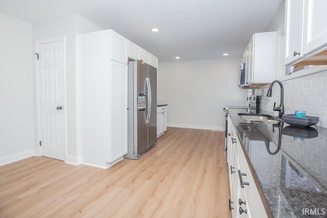 6400 Jefferson Ave, Evansville, IN 47715 - kitchen featuring a sink, white cabinets, appliances with stainless steel finishes, backsplash, and dark stone countertops