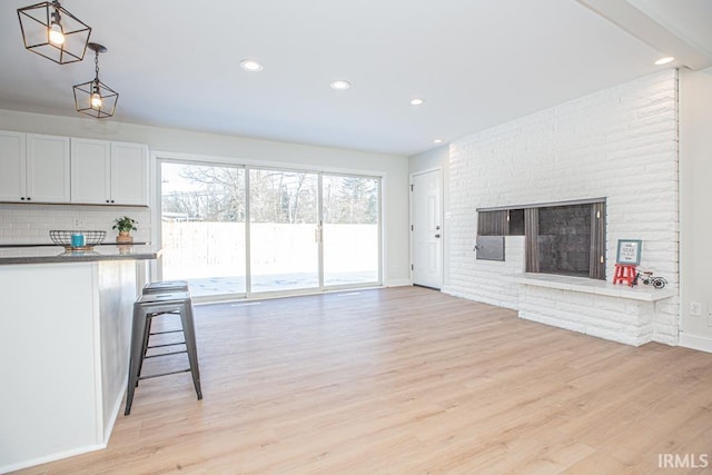 6400 Jefferson Ave, Evansville, IN 47715 - unfurnished living room featuring a brick fireplace, recessed lighting, and light wood-style floors