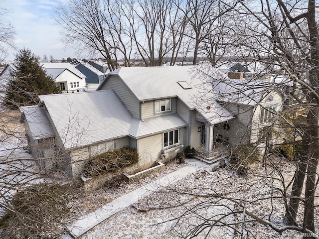 exterior space with roof with shingles and a chimney