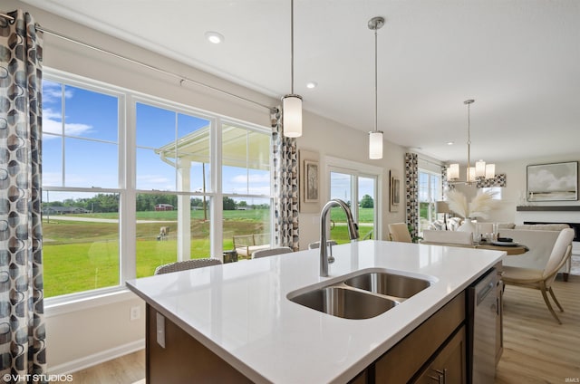 8973 Belmont Woods, Fort Wayne, IN 46835 - kitchen featuring dishwasher, a kitchen island with sink, light countertops, pendant lighting, and a sink