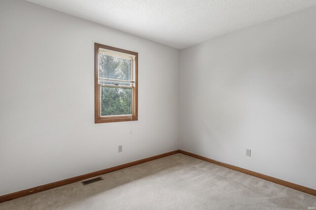 7910 Moss Grove Pl, Fort Wayne, IN 46825 - spare room with baseboards, light colored carpet, a textured ceiling, and visible vents
