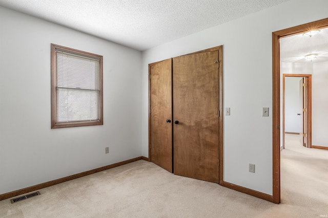 7910 Moss Grove Pl, Fort Wayne, IN 46825 - unfurnished bedroom featuring a textured ceiling, light colored carpet, visible vents, and a closet