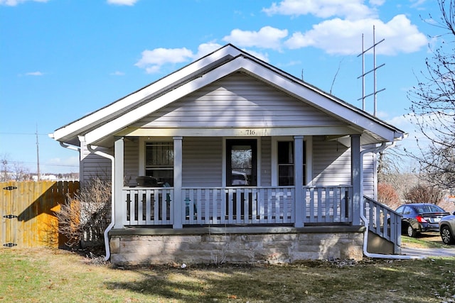 bungalow-style house with a porch and a front lawn