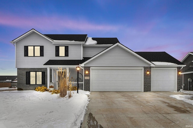 traditional-style house with brick siding, driveway, and an attached garage