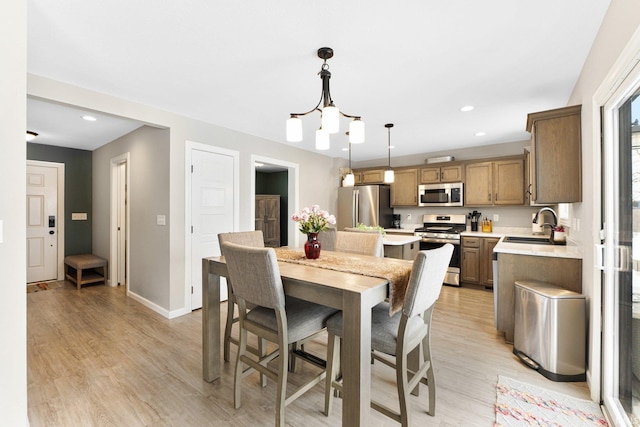 dining room with light wood-style floors, baseboards, and recessed lighting