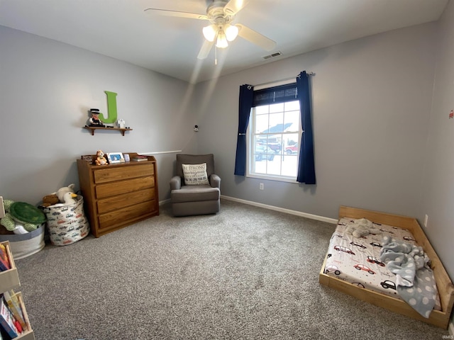 sitting room featuring a ceiling fan, baseboards, visible vents, and carpet flooring