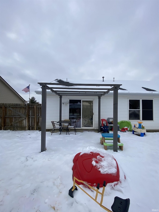 snow covered property featuring fence and a pergola