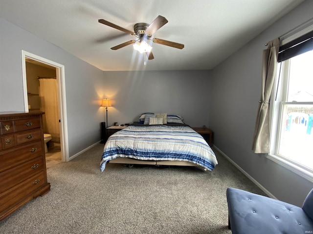 carpeted bedroom featuring ceiling fan, baseboards, and connected bathroom