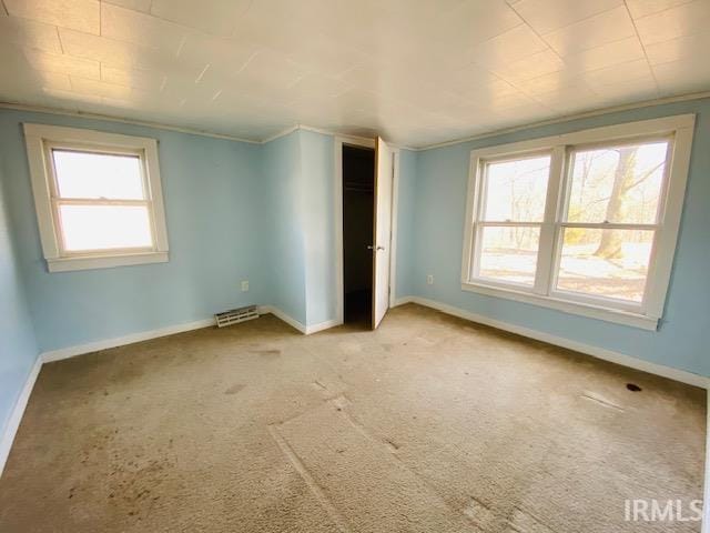 unfurnished bedroom featuring visible vents, light colored carpet, and baseboards