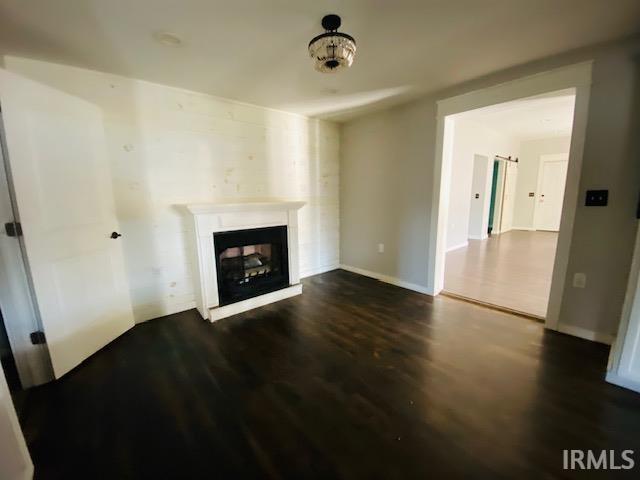 living room with dark wood-style floors, a fireplace, and baseboards