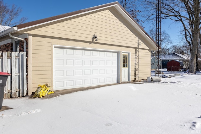 snow covered garage with a garage