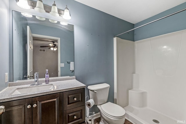 bathroom featuring visible vents, toilet, a ceiling fan, a stall shower, and vanity