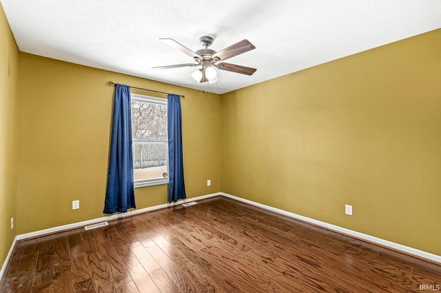 unfurnished room featuring a ceiling fan, visible vents, baseboards, and wood finished floors