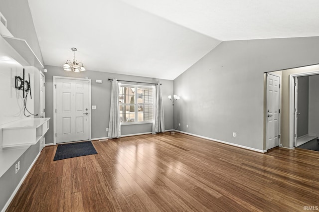 foyer with lofted ceiling, baseboards, an inviting chandelier, and wood finished floors