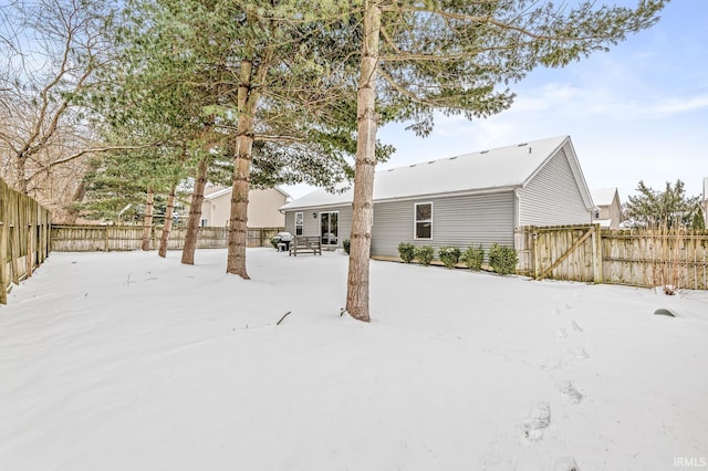 snow covered house featuring fence