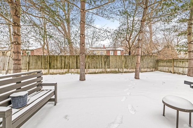 yard covered in snow featuring a fenced backyard