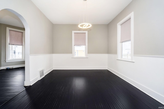 602 N Harrison St, Alexandria, IN 46001 - spare room with arched walkways, plenty of natural light, dark wood finished floors, and visible vents