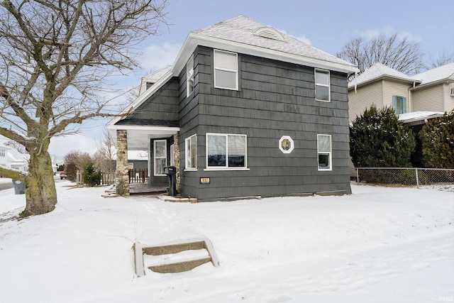 view of front of home with roof with shingles and fence