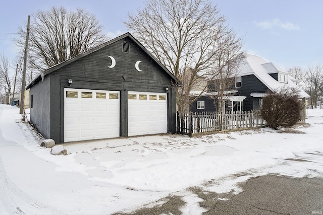 602 N Harrison St, Alexandria, IN 46001 - snow covered garage featuring a detached garage and fence