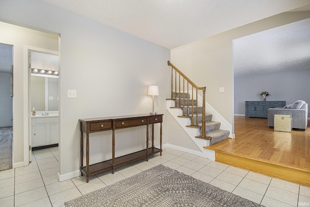 stairs with baseboards, a textured ceiling, and tile patterned floors