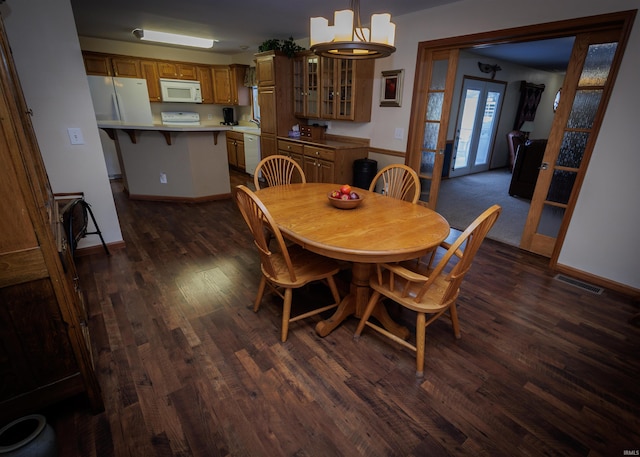 dining space featuring dark wood-style floors, visible vents, and baseboards