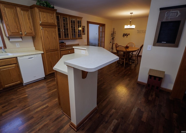 kitchen featuring brown cabinetry, dishwasher, a center island, hanging light fixtures, and light countertops