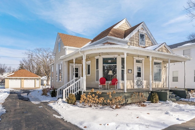 view of front of home with covered porch, a detached garage, and an outdoor structure