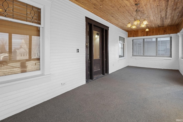 unfurnished sunroom with wooden ceiling and an inviting chandelier