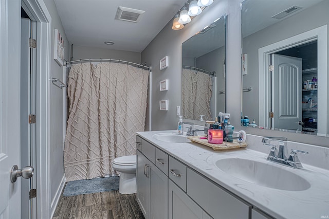 full bath with wood finished floors, a sink, and visible vents