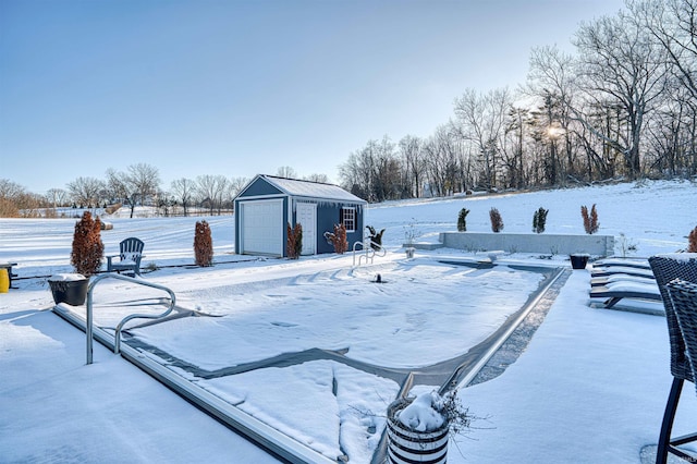 yard layered in snow with a detached garage and an outbuilding