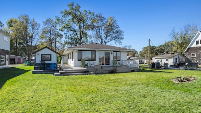 back of property with a deck and a lawn