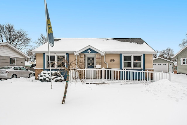 bungalow-style house with a garage and an outbuilding