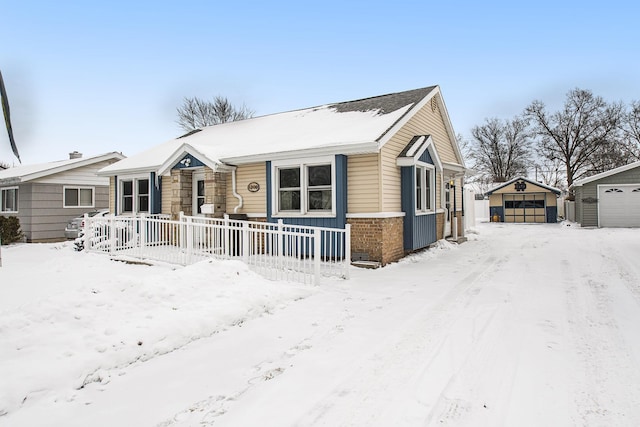 view of front of home with a garage, brick siding, and an outdoor structure