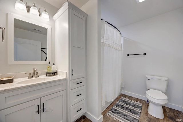 full bathroom with toilet, a shower with shower curtain, wood finished floors, vanity, and baseboards