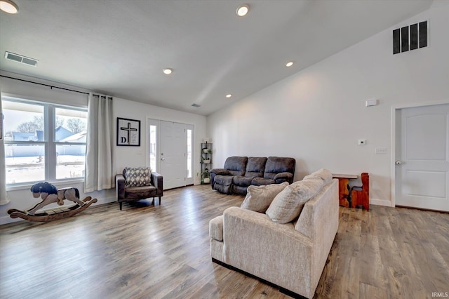 living room featuring lofted ceiling, wood finished floors, visible vents, and recessed lighting