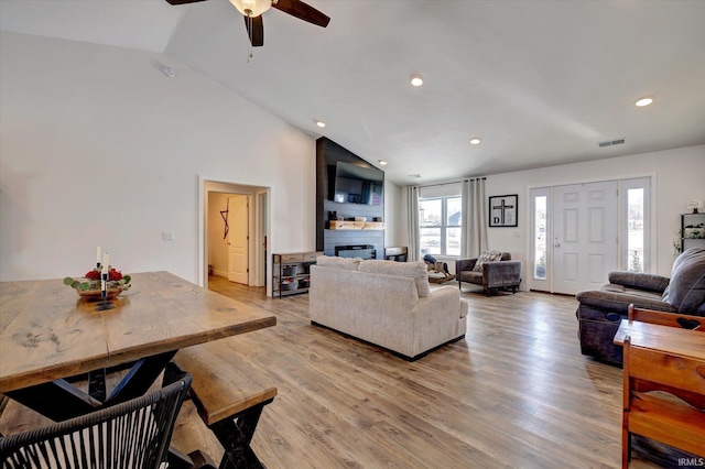 living room with light wood-type flooring, a fireplace, visible vents, and recessed lighting