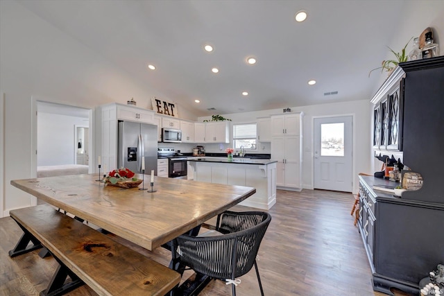 dining room with high vaulted ceiling, recessed lighting, visible vents, and light wood-style flooring