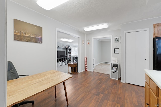 home office with a textured ceiling, a baseboard heating unit, and dark wood-type flooring