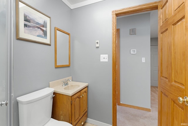 bathroom featuring baseboards, vanity, and toilet