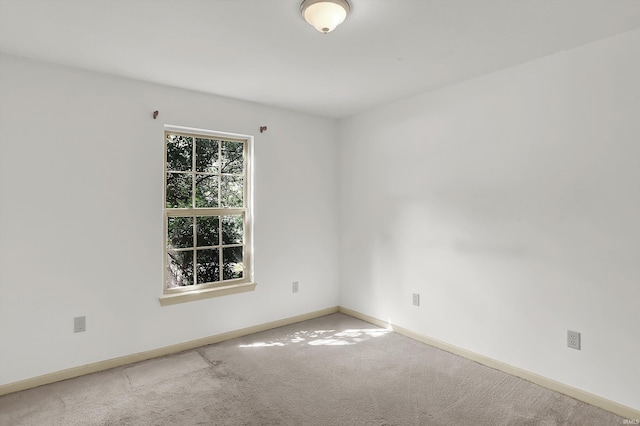 empty room featuring baseboards and carpet flooring
