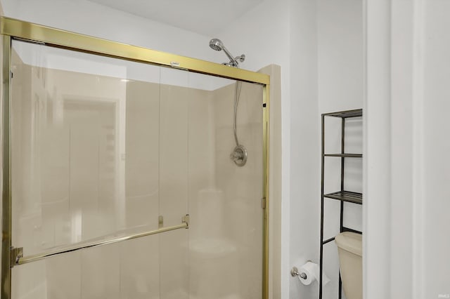 full bathroom featuring a stall shower and toilet