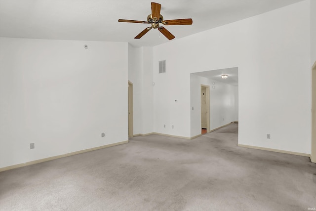 unfurnished room featuring high vaulted ceiling, baseboards, visible vents, and light colored carpet