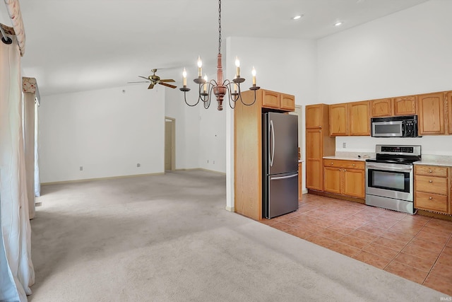 kitchen featuring decorative light fixtures, stainless steel appliances, light countertops, and open floor plan