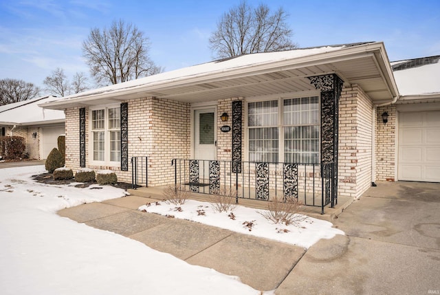 view of front facade featuring a garage, driveway, and brick siding