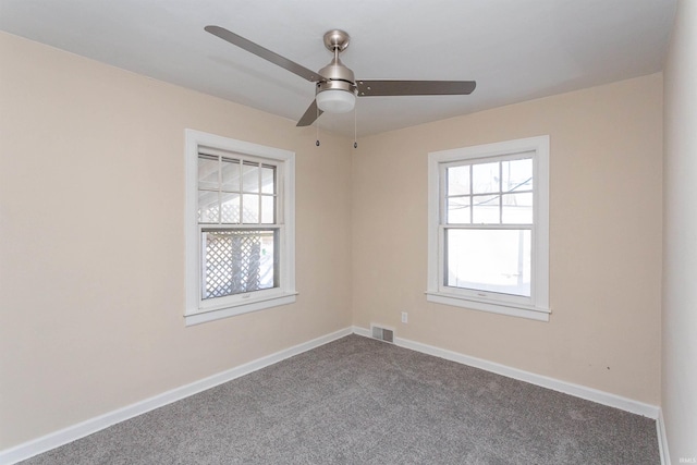 empty room featuring a ceiling fan, carpet, visible vents, and baseboards