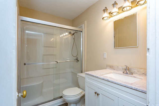 bathroom with a stall shower, vanity, and toilet